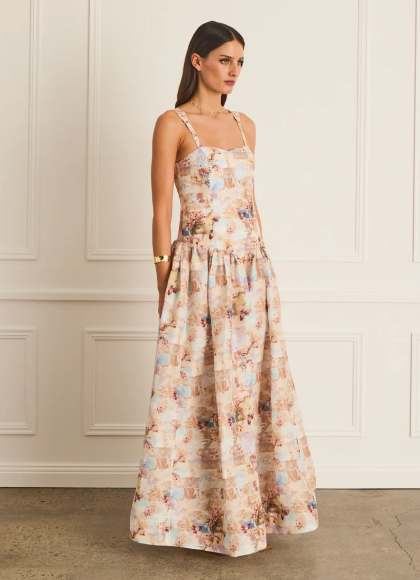 Woman wearing a floral dress against a white wall