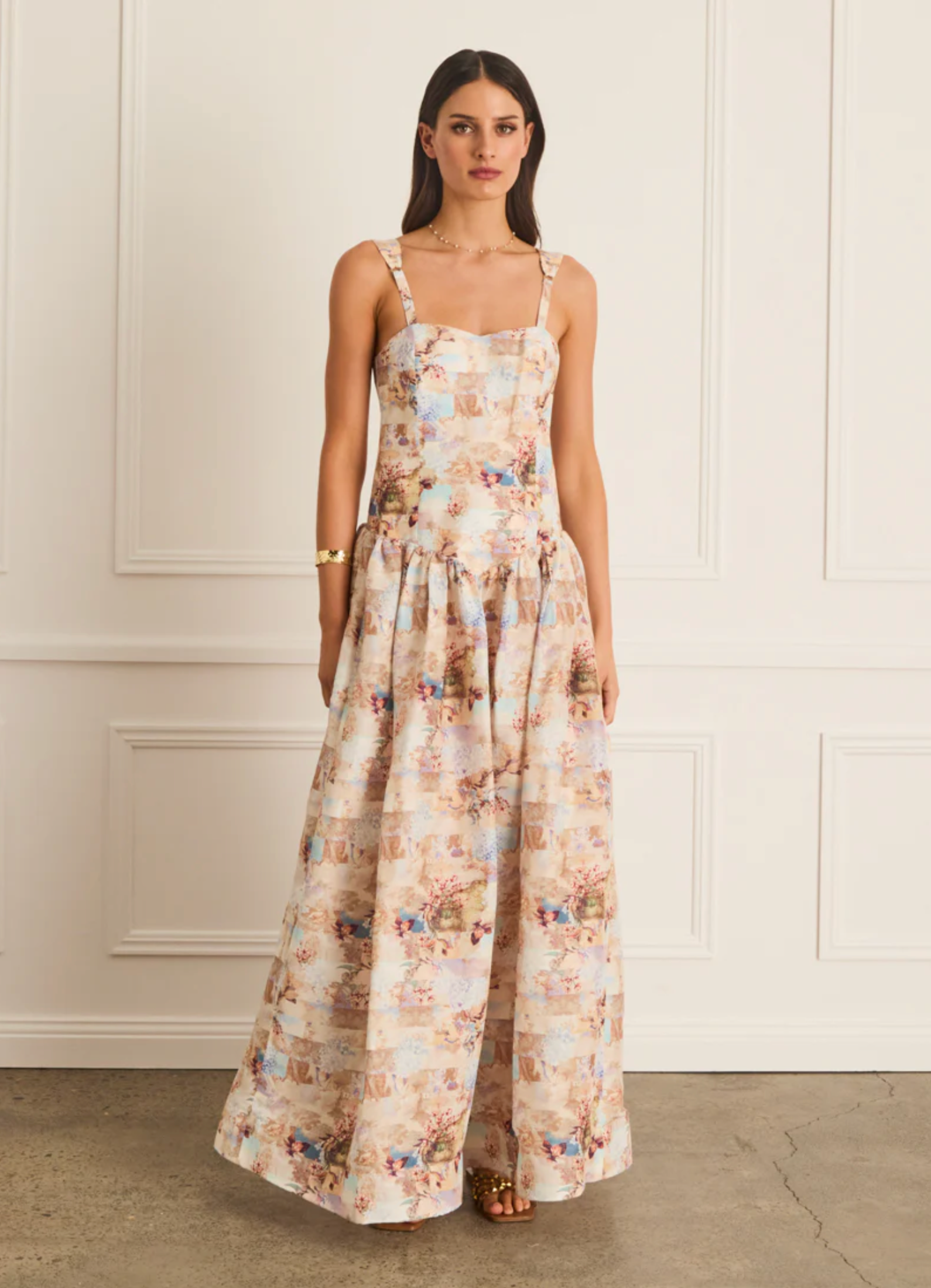 Woman wearing a floral dress against a white wall