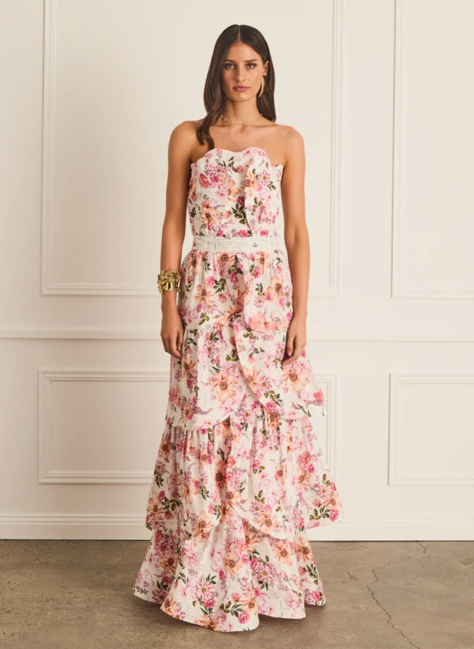 Woman wearing a floral strapless dress against a neutral background