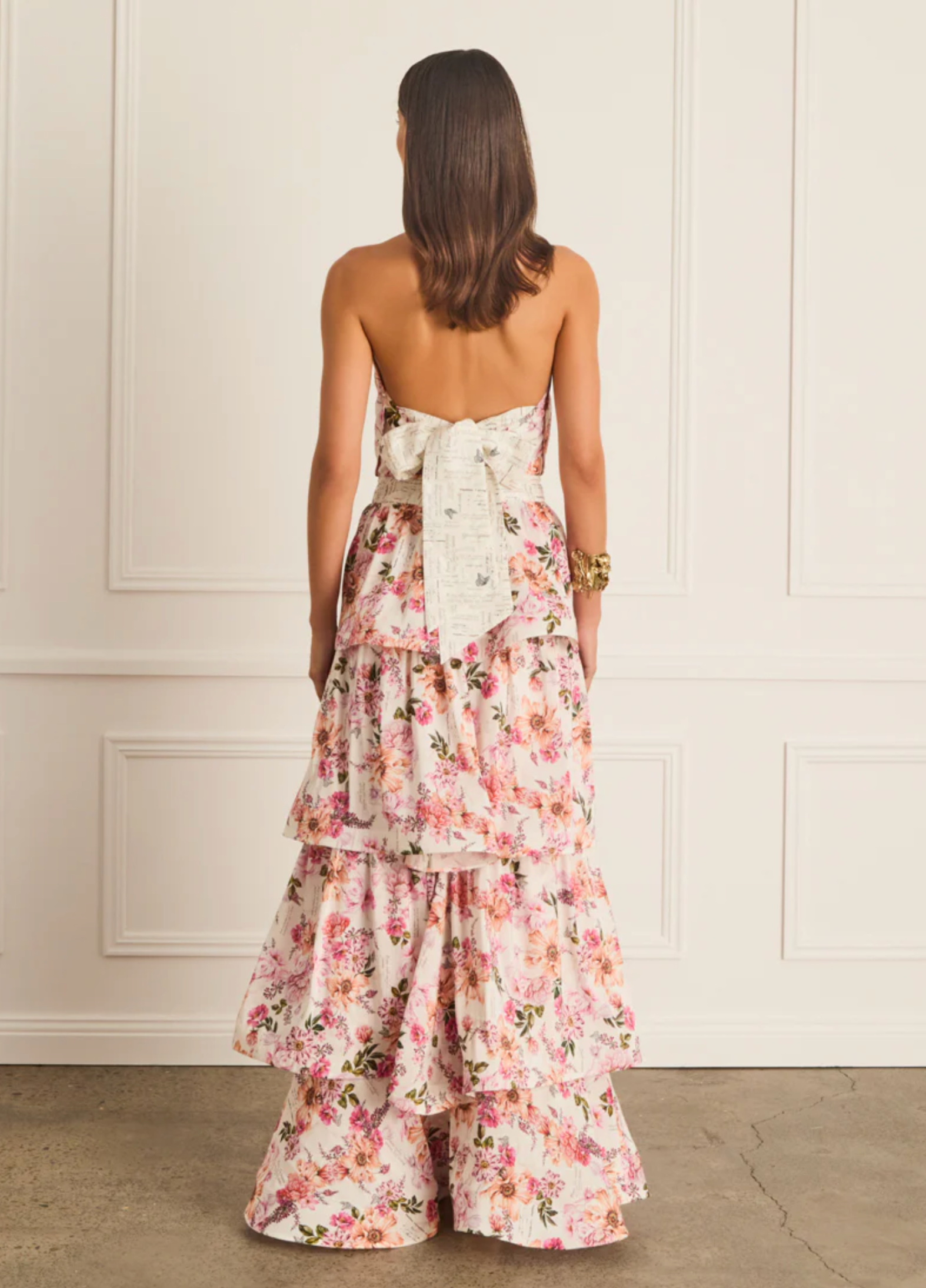 Woman wearing a floral dress with a white wall background
