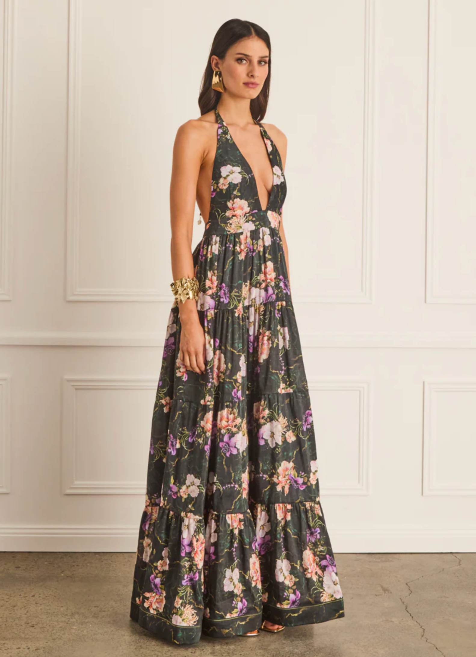 Woman wearing a floral dress against a white wall