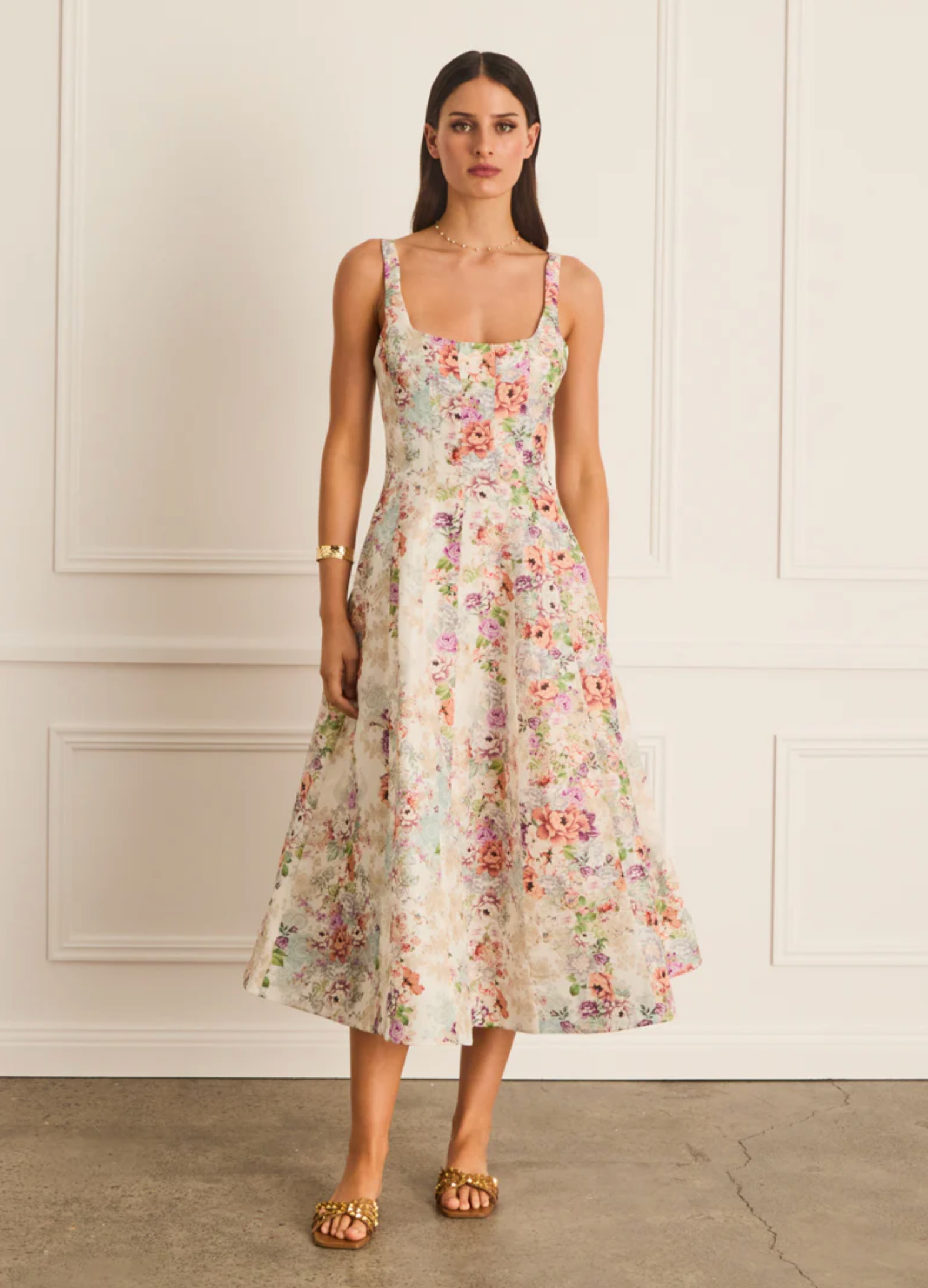 Woman wearing a floral dress against a white wall