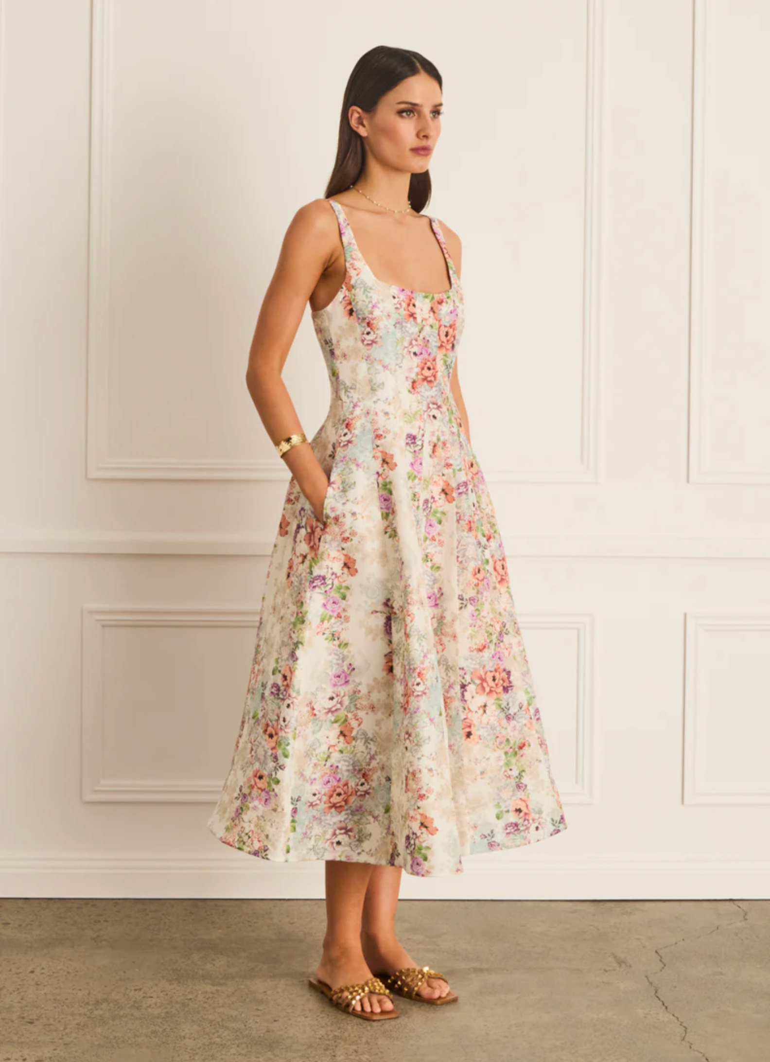 Woman wearing a floral dress against a white wall