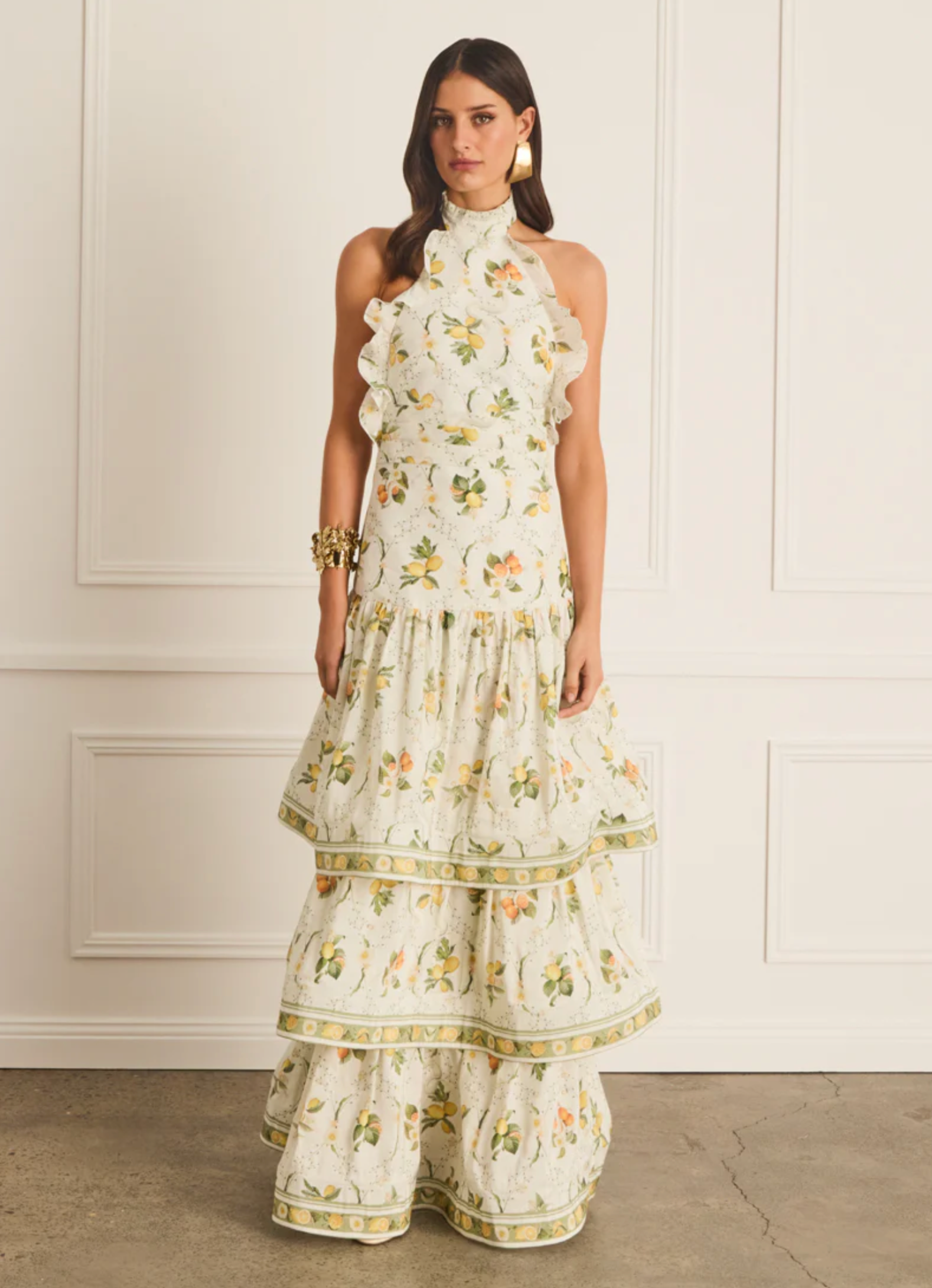 Woman wearing a floral dress against a white wall