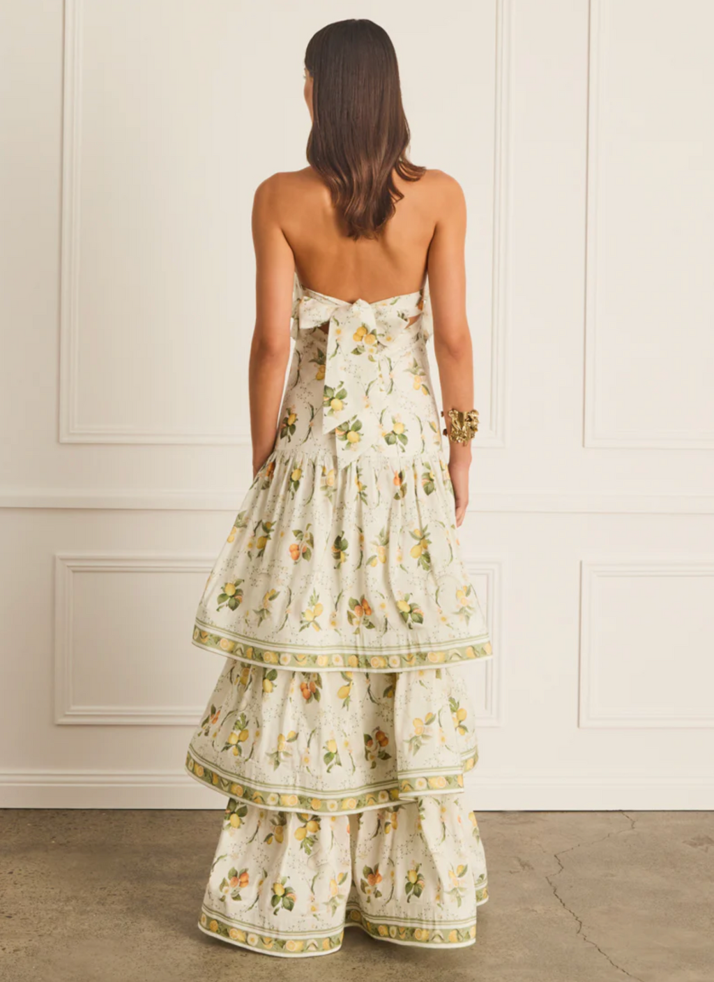 Woman wearing a floral dress with a white paneled wall background