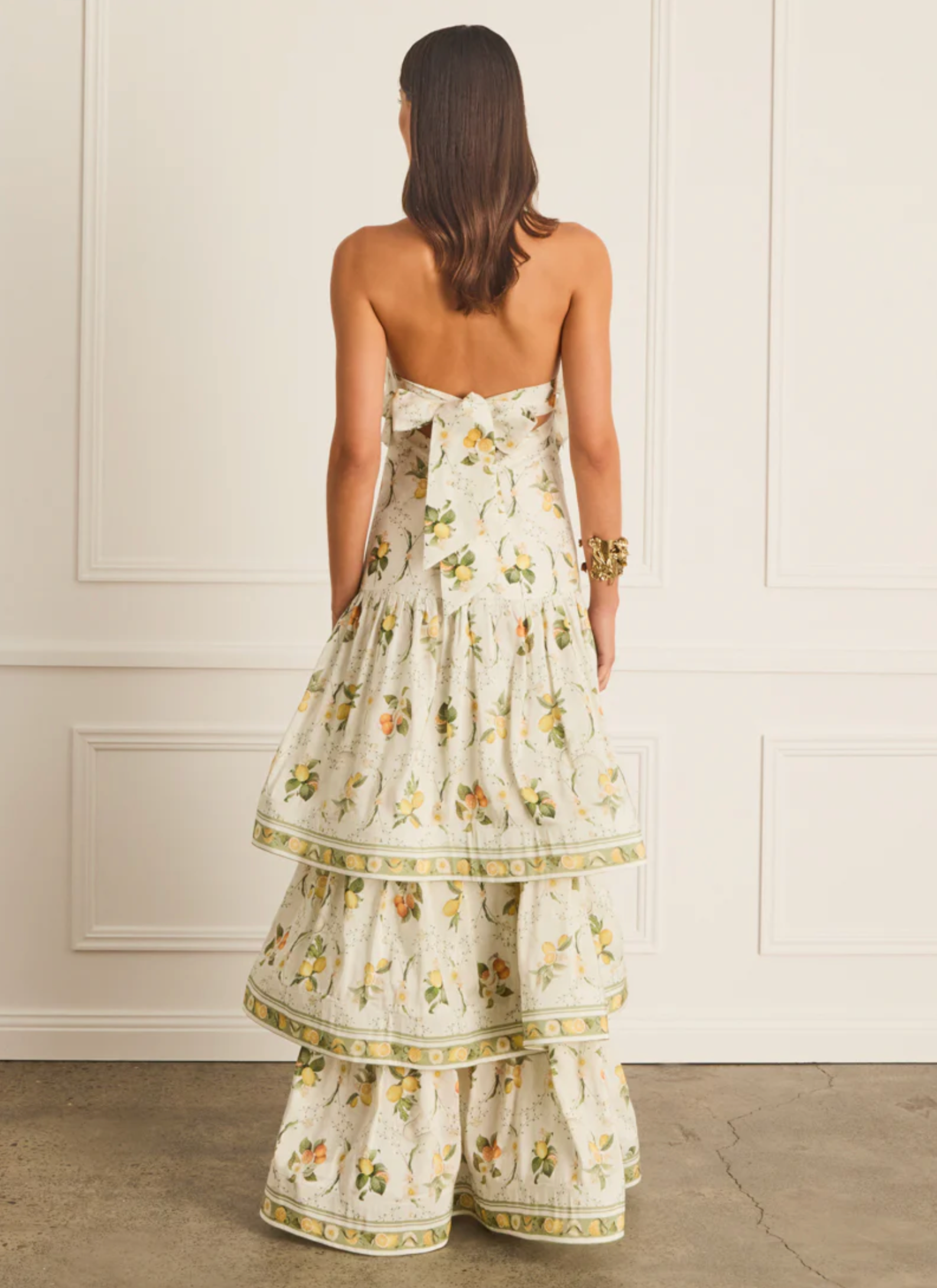 Woman wearing a floral dress with a white paneled wall background