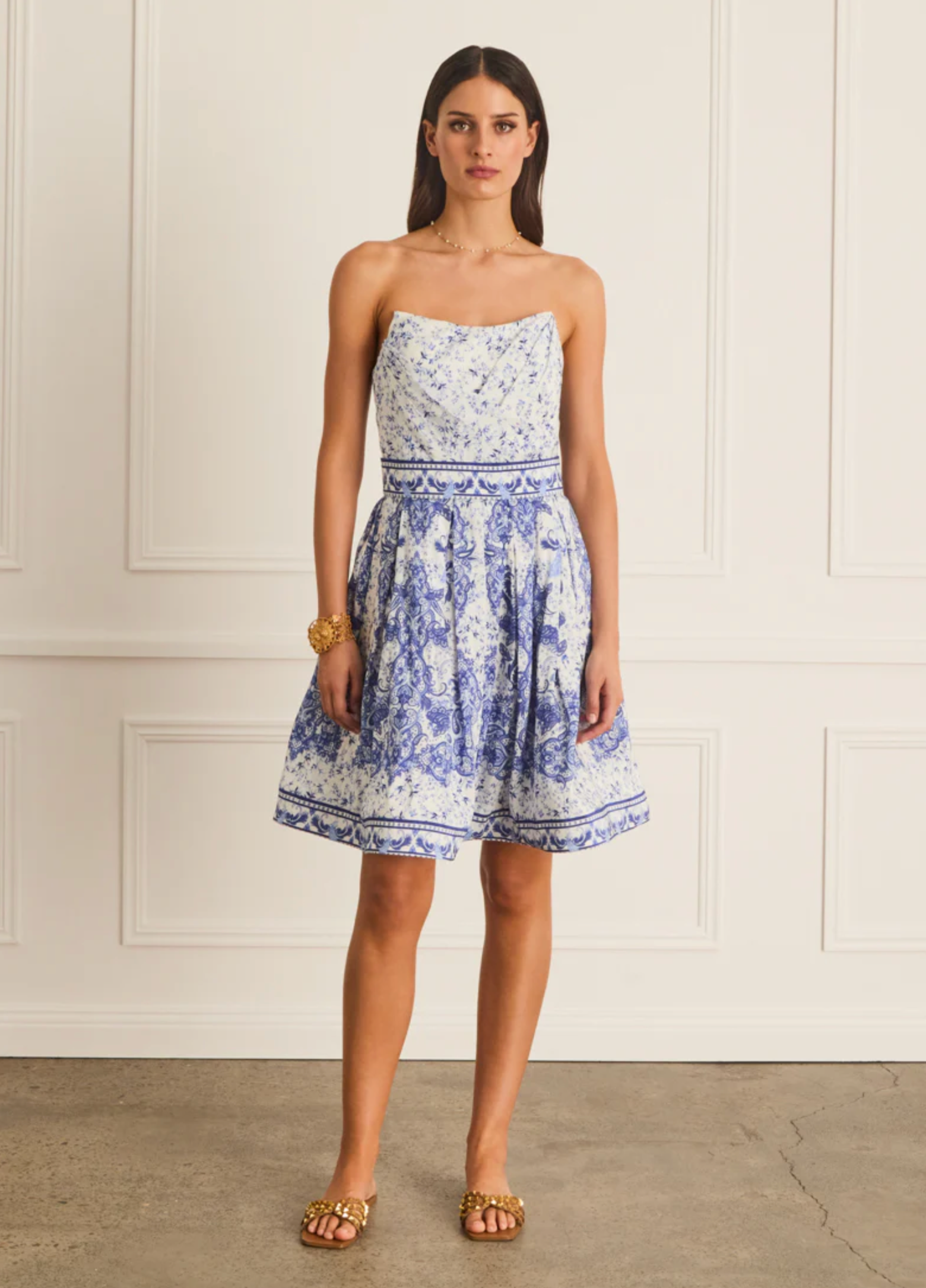 Woman wearing a strapless floral dress with a white background